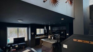 A modern living room with a sofa, a TV, and a 'WELCOME' sign. - Romantic Getaway, Tiny High-Rise Cabin (Whitemouth)