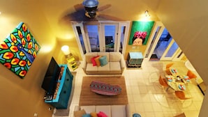 A living room with a sofa, coffee table, and a dining area with a table and chairs. - Your Lake Front Hideaway in Paradise Hideaway in Paradise - 7BR Luxurious Villa (Kissimmee)