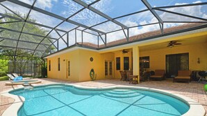 An indoor swimming pool with a glass ceiling, yellow walls, and a patio area with furniture. - Private Pool & Spa | Rare Wooded View | Minutes to Disney | Game Room & BBQ ⭐ Best overall (Kissimmee)