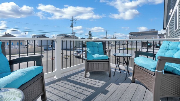 A balcony with wicker furniture and a view of the street.