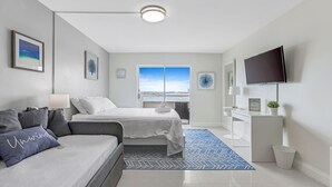 A modern bedroom with a bed, a sofa, a TV, and a window with a view. - Waterfront condo Studio - Free Parking (North Bay Village)