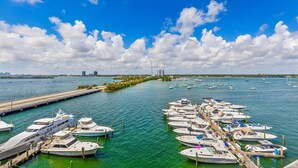 A marina with numerous boats docked, a clear blue sky, and a distant city skyline. - Waterfront condo Studio - Free Parking (North Bay Village)