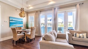 A living room with a dining area, a sofa, and a chandelier. - TaDa! - Heated Pool and Golf Cart! (Santa Rosa Beach)