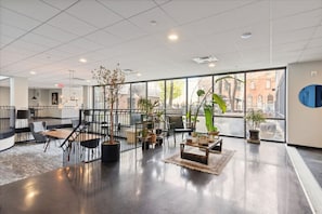 Experience the grandeur of our lobby, featuring a high ceiling, central staircase, and comfortable seating areas.