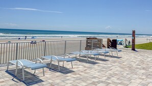 A beachside patio with metal benches and a view of the ocean. - Ground Floor Beachfront Complex Unit w/Pool & Beach Access (New Smyrna Beach)
