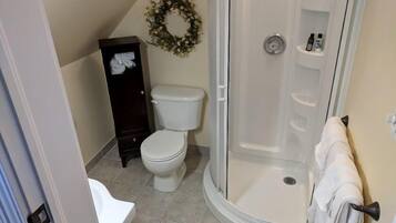 A bathroom with a toilet, a shower, and a towel rack.