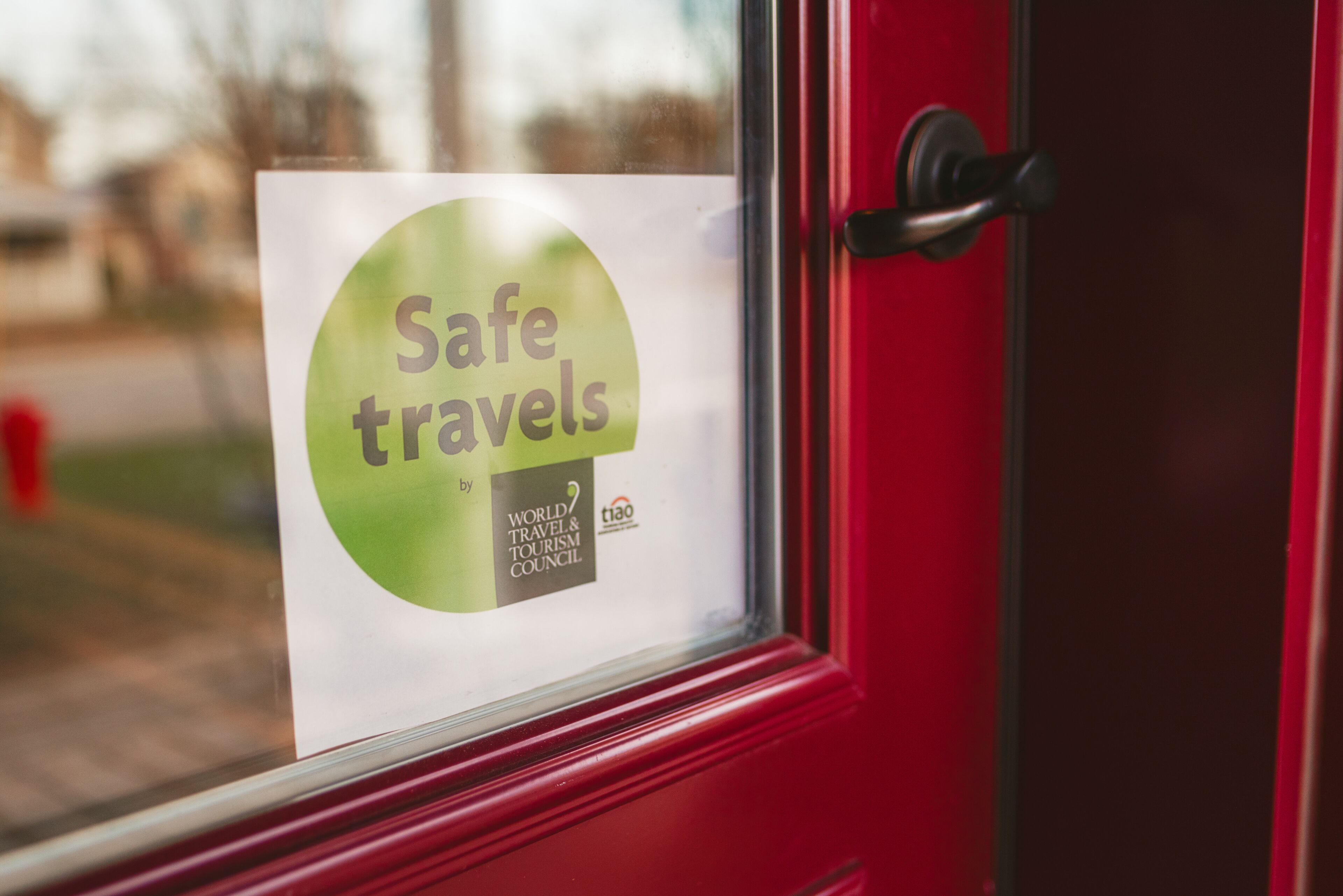 A window with a sign that reads "Safe travels by World Travel & Tourism Council."