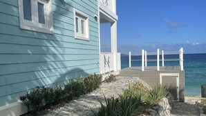 A coastal building with a stone pathway leading to a dock.