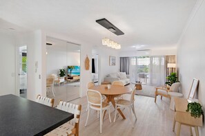 Ein stilvoller Wohnbereich mit Essbereich, einer Couch und einem Fernseher im Hintergrund.