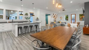 A modern kitchen with a large island, bar stools, and pendant lighting. - Walk to the waterfront- Charmwood House  (Tacoma)