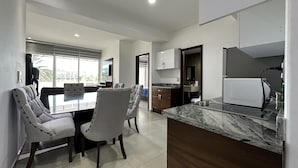 A modern kitchen with a marble countertop, wooden cabinets, and a built-in oven. - Pacifika Marina Mazatlan by Partnerhost (Mazatlán)