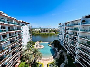A high-rise hotel with multiple balconies, a central swimming pool, and surrounding greenery. - Pacifika Marina Mazatlan by Partnerhost (Mazatlán)