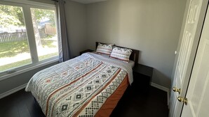 Un dormitorio con una cama, una ventana y una puerta.