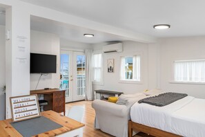 A modern, well-lit room with a bed, a desk, and a TV. - Walk to the waterfront The Hobbit House (Tacoma)
