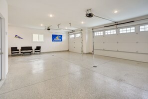 Un vaste espace intérieur doté d’un sol en béton poli, d’une rangée de chaises, d’un drapeau et d’une porte de garage.