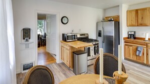 A kitchen with wooden cabinets, a stainless steel refrigerator, a microwave, and a stove.