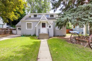 A two-story house with a front porch, a small front yard, and a wooden fence. - Charming Hamilton Hideaway: Half-Mi to Main St! (Hamilton)