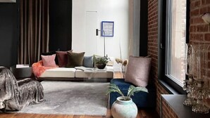 Una sala de estar moderna con un sofá seccional, una mesa de centro y un florero con plantas secas.