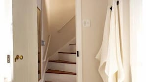 A hallway with a staircase leading to a room.