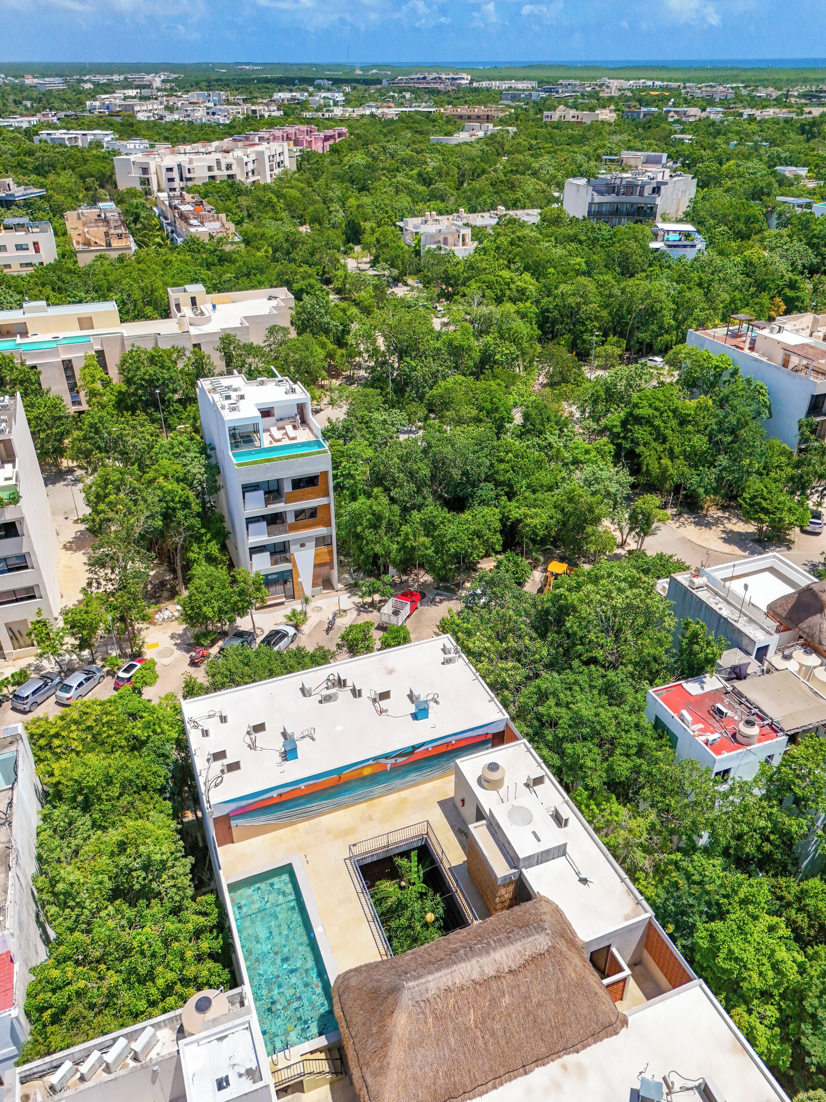 A residential area with modern buildings, a swimming pool, and lush greenery.