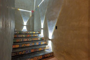 Una escalera con baldosas de colores y una lámpara.