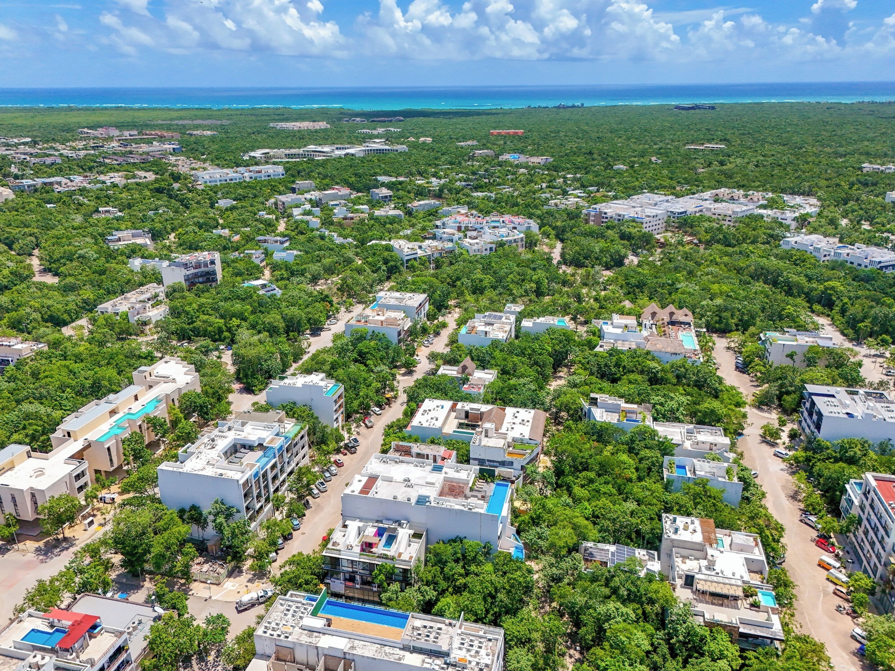 An aerial view of a residential area with multiple buildings, roads, and greenery.