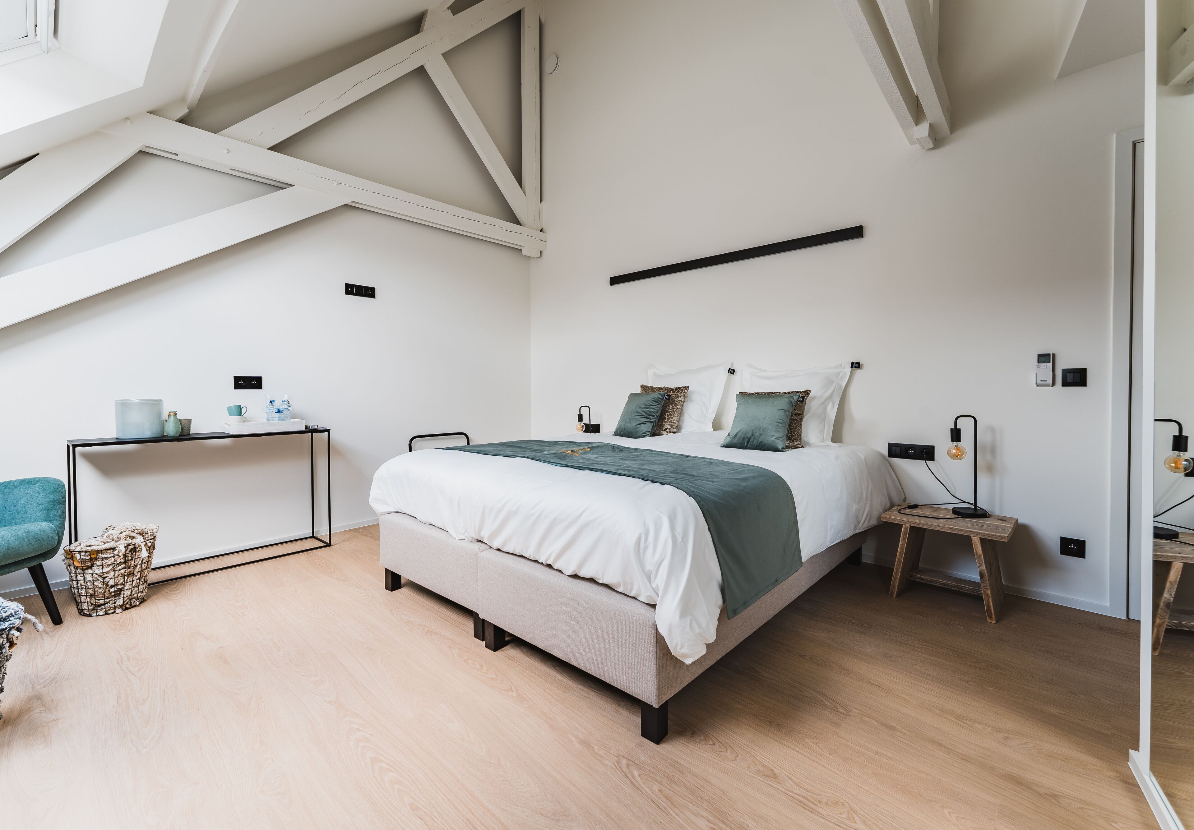 Een slaapkamer met een bed, nachtkastjes, een bureau en een stoel.