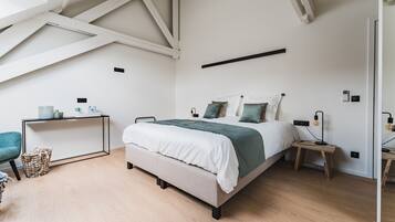 Een slaapkamer met een bed, nachtkastjes, een bureau en een stoel.