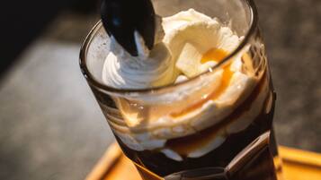 A glass with a layered drink, possibly a cocktail, on a tray.