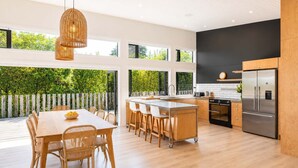 Una cocina moderna con una isla grande, muebles de madera y vistas a zonas verdes.
