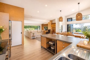 Une cuisine moderne dotée d’un îlot central, de meubles en bois et d’un coin repas offrant une vue agréable.