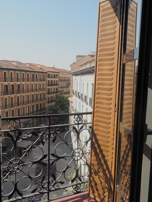 A balcony with a wrought iron railing overlooking a street with buildings. - Sunny Loft Historic District - Sol (Madrid)