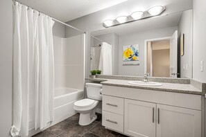 A modern bathroom with a bathtub, toilet, and sink. - New Edmonton House 10 mins to Airport, Super close to best places in Edmonton (Edmonton)