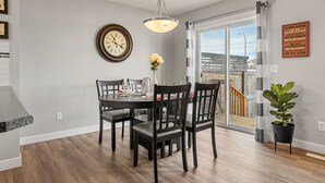 A dining area with a round table, four chairs, a clock, and a potted plant. - New Edmonton House 10 mins to Airport, Super close to best places in Edmonton (Edmonton)