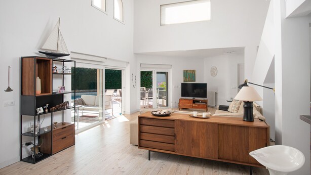 A spacious living area with a wooden cabinet, a television, and a lamp. - Villa Estranys (Alcúdia)