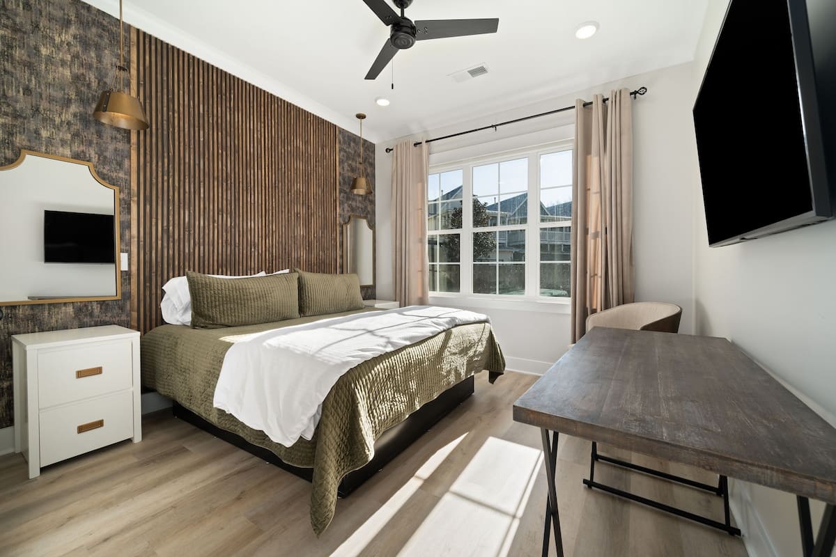 Une chambre à coucher avec un lit, une table de chevet et un bureau.