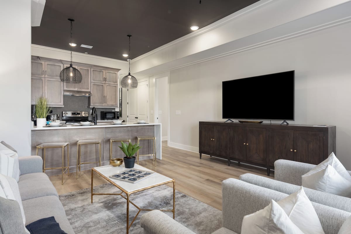 Un salon moderne avec un canapé, une table basse et un téléviseur posé sur un meuble.