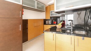Une cuisine moderne avec des meubles en bois, un évier en acier inoxydable et un four à micro-ondes.