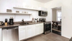 A modern kitchen with white cabinets, stainless steel appliances, and a granite countertop.