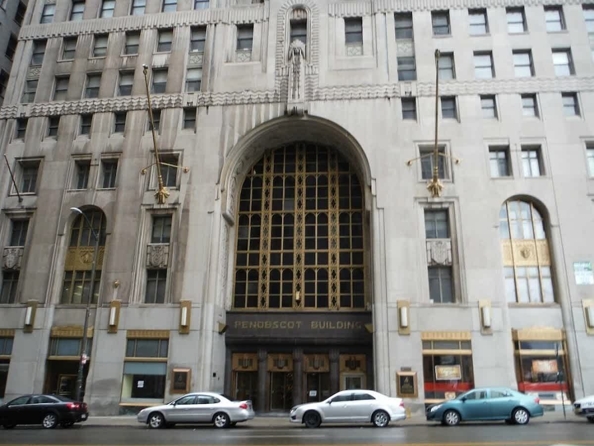 Un edificio grande con una entrada arqueada destacada y varias ventanas.
