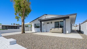 A modern house with a white exterior, a covered patio, and a tree in the yard. -  Stepping Stones  away from the Colorado River. (Bullhead City)