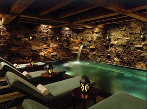 A spa area with a stone wall, a small waterfall, and lounge chairs with lanterns. - RITZ-CARLTON @Beaver Creek Ski-IN & ski-OUT 2BR, 2Bath LUXURY Residential suite (Beaver Creek)