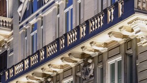 A building facade with classical architectural details, including ornate cornices and a balcony with balustrades.