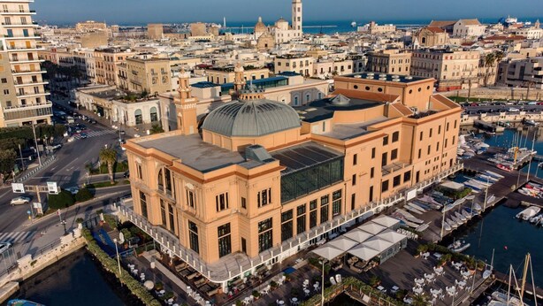 A waterfront building with a prominent dome and adjacent marina.
