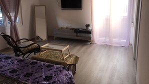 A room with a bed, a chair, a small table, a dresser, and a TV mounted on the wall. - 2 Bedroom Bed & breakfast in Modena (Modena)