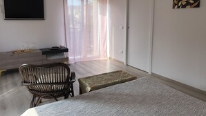 A bedroom with a bed, a chair, a small table, a TV, and a door. - 2 Bedroom Bed & breakfast in Modena (Modena)