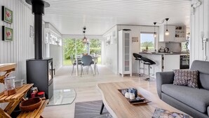 Un espace de vie moderne, à aire ouverte, comprenant une cuisine, un coin repas et un espace salon confortable.