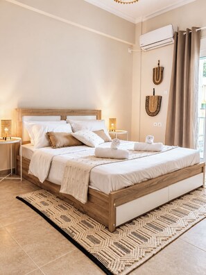 Ein Schlafzimmer mit einem hölzernen Bett, weißer Bettwäsche, einem gewebten Teppich und einer Klimaanlage an der Wand.