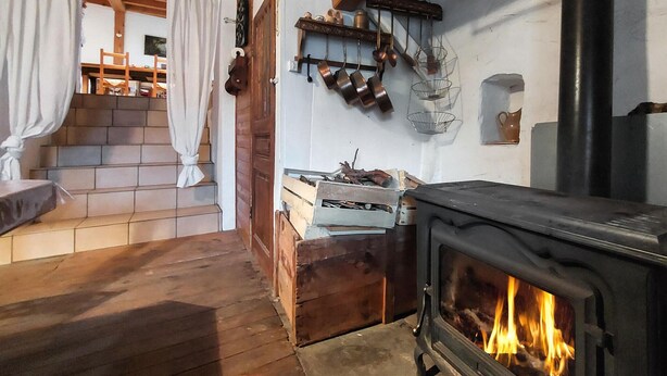 A cozy room with a fireplace, wooden stairs, and a dining area. - 2 bedroom amazing home in Bas-en-Basset (Bas-en-Basset)
