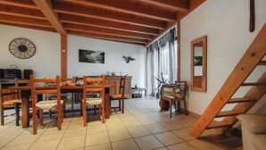 A dining area with wooden furniture, a clock, and artwork on the walls. - 2 bedroom amazing home in Bas-en-Basset (Bas-en-Basset)